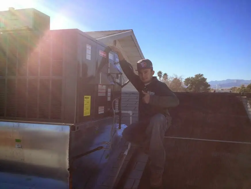 HVAC technician performing AC Tune-Up on a rooftop unit in Greenacres